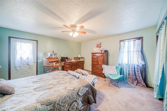 bedroom featuring ceiling fan, light colored carpet, and a textured ceiling