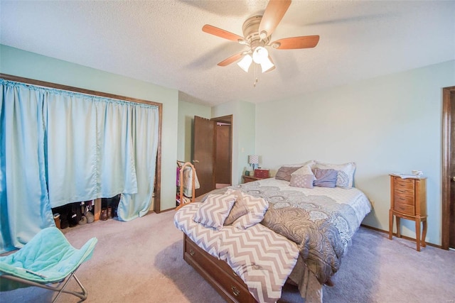 carpeted bedroom featuring a textured ceiling and ceiling fan