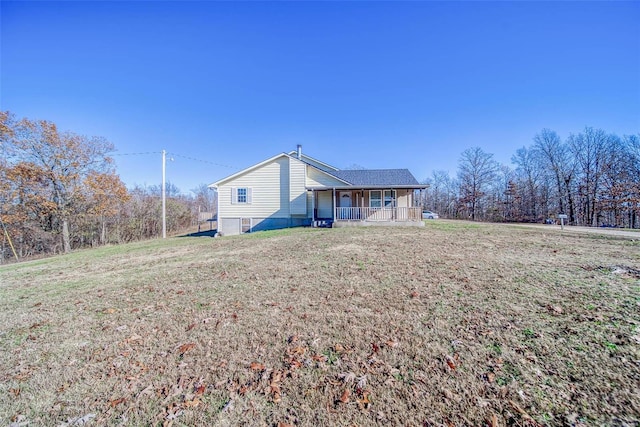 back of house with covered porch and a yard