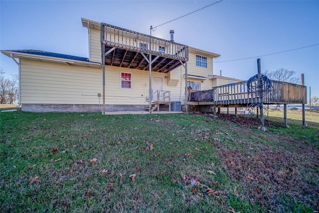 rear view of property with a yard and a wooden deck