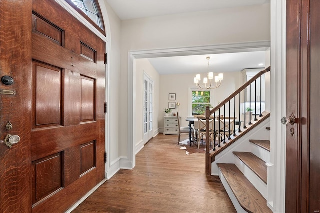 entryway featuring hardwood / wood-style flooring and a chandelier