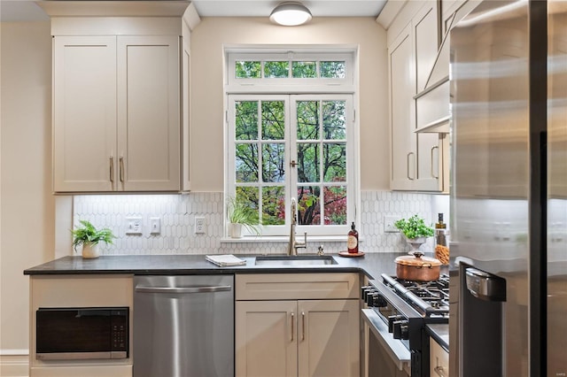 kitchen featuring white cabinetry, decorative backsplash, sink, and appliances with stainless steel finishes