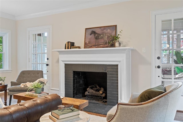 living room with a fireplace, wood-type flooring, and ornamental molding