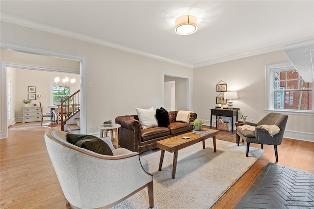 living room featuring a wealth of natural light, crown molding, and light wood-type flooring