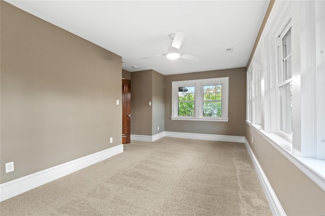 empty room featuring ceiling fan and light colored carpet