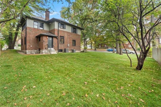 back of house featuring a yard and central AC