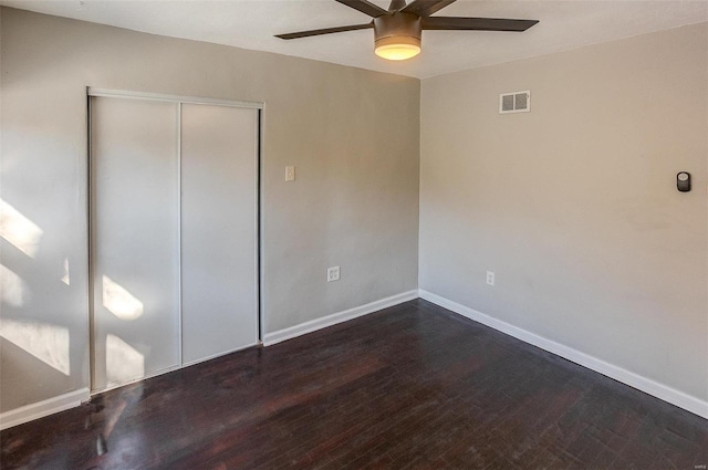 unfurnished bedroom featuring a closet, ceiling fan, and dark wood-type flooring