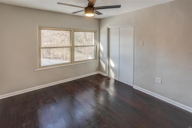 unfurnished bedroom with a closet, ceiling fan, and dark wood-type flooring