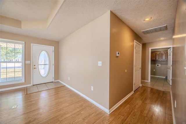 foyer featuring light hardwood / wood-style flooring and a textured ceiling