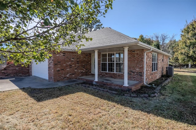 view of home's exterior with cooling unit, a yard, and a garage