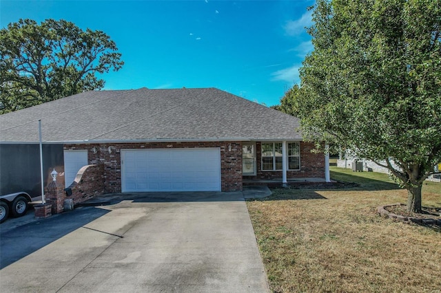 ranch-style house featuring a front lawn and a garage