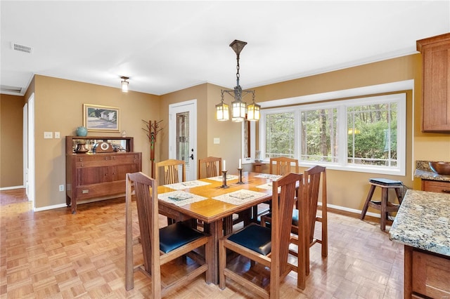 dining space featuring a chandelier and light parquet floors