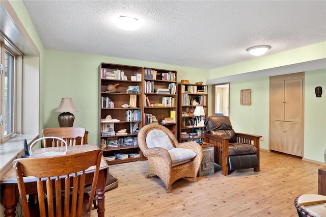 living area with plenty of natural light, a textured ceiling, and light wood-type flooring