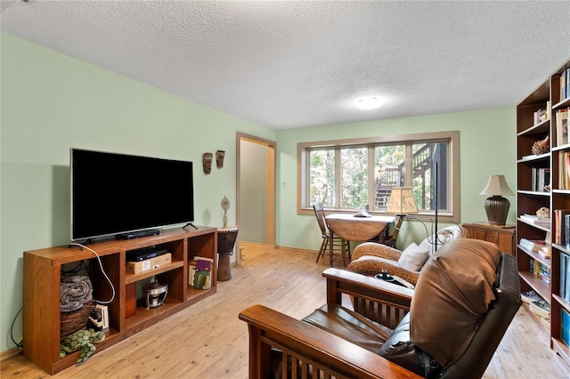 living room with a textured ceiling and light wood-type flooring