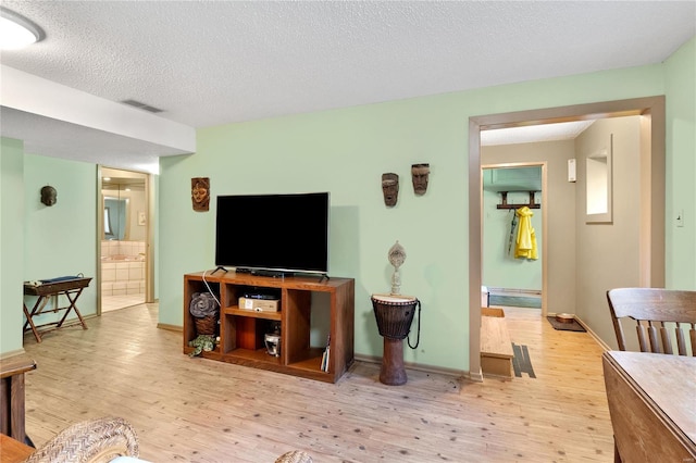 living room with a textured ceiling and light wood-type flooring