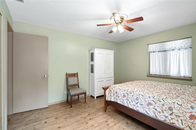 bedroom featuring light hardwood / wood-style floors, a textured ceiling, a closet, and ceiling fan