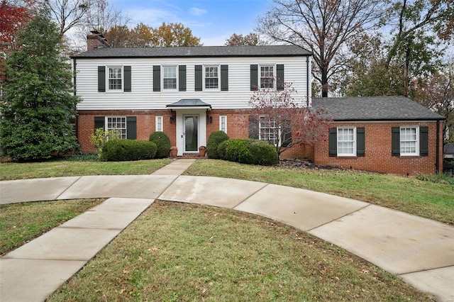 colonial-style house featuring a front lawn