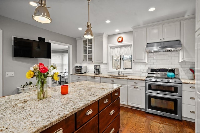 kitchen featuring sink, hardwood / wood-style flooring, appliances with stainless steel finishes, decorative light fixtures, and white cabinetry