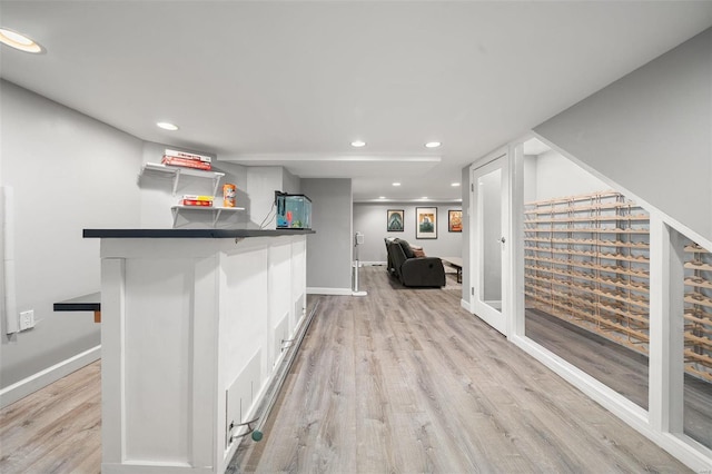 bar featuring white cabinetry and light hardwood / wood-style flooring