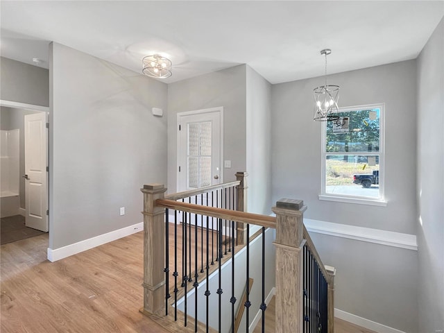 hallway featuring an inviting chandelier and light wood-type flooring