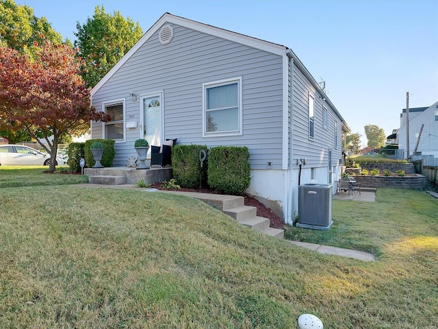 view of front of home featuring a front yard and cooling unit