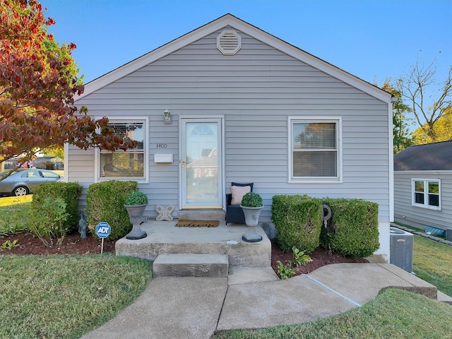 bungalow-style house with central AC and a front lawn