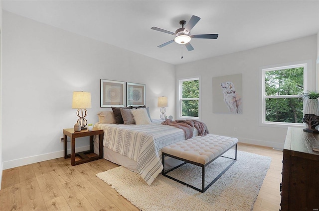 bedroom with light hardwood / wood-style flooring, multiple windows, and ceiling fan