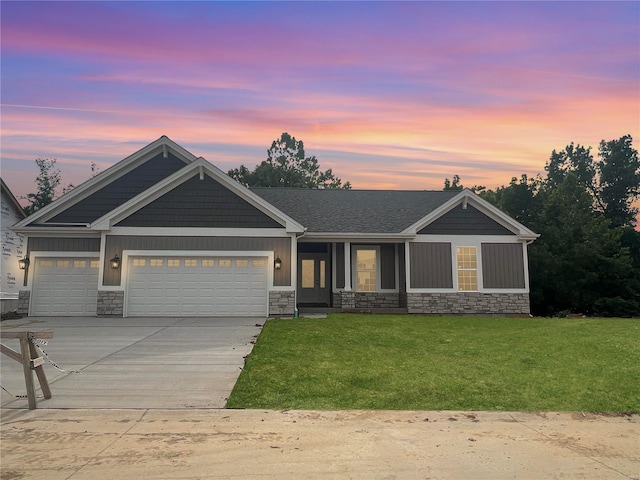 craftsman inspired home featuring a garage and a lawn