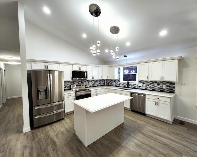 kitchen with sink, a kitchen island, high vaulted ceiling, pendant lighting, and appliances with stainless steel finishes