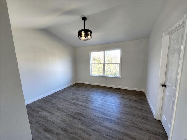 spare room with lofted ceiling and dark hardwood / wood-style flooring