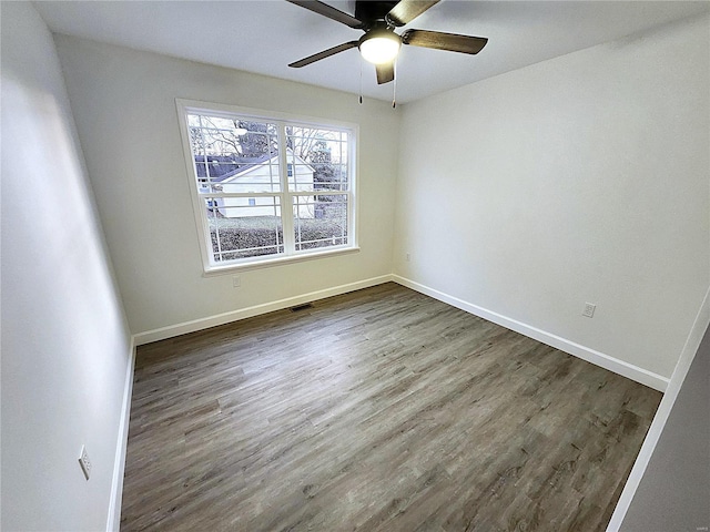 empty room with ceiling fan and dark hardwood / wood-style floors