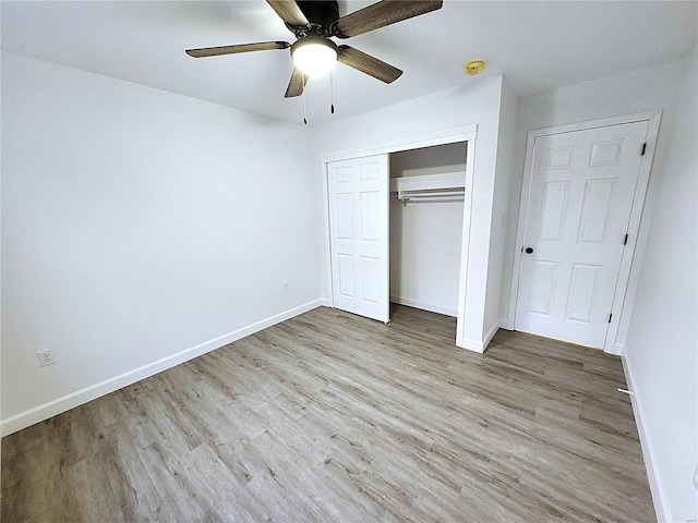 unfurnished bedroom featuring ceiling fan, light hardwood / wood-style floors, and a closet