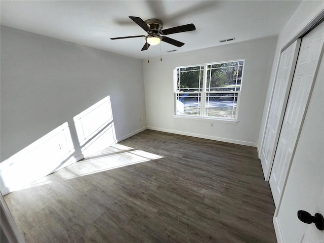 unfurnished bedroom with a closet, ceiling fan, and dark hardwood / wood-style floors