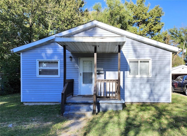 bungalow featuring covered porch and a front yard