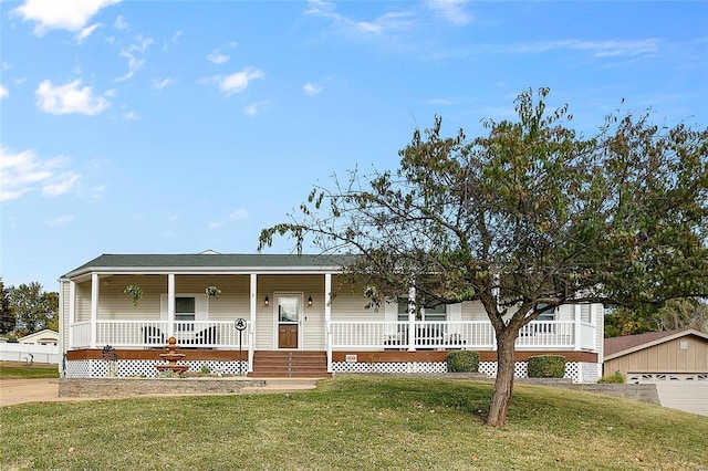 view of front of house featuring covered porch, a garage, an outdoor structure, and a front yard