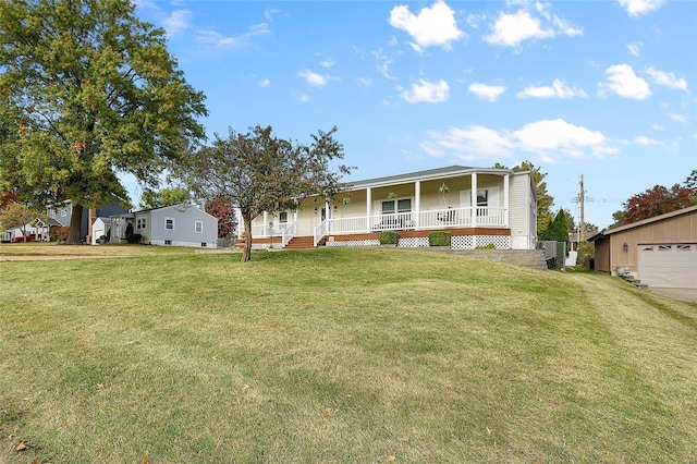 view of front of house featuring covered porch, a garage, an outbuilding, and a front lawn