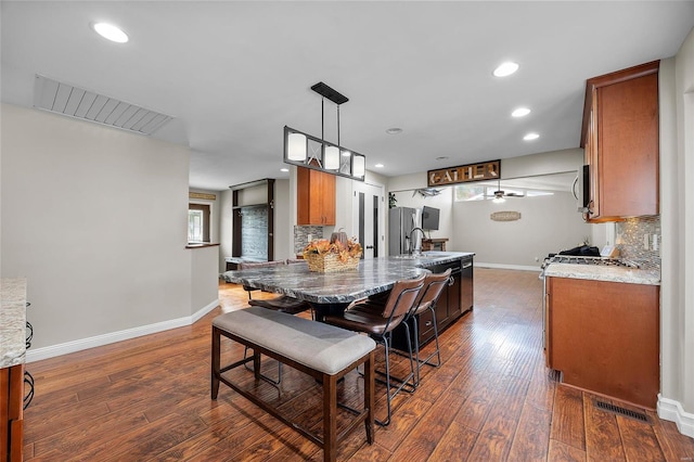 dining area featuring ceiling fan, dark hardwood / wood-style flooring, and sink