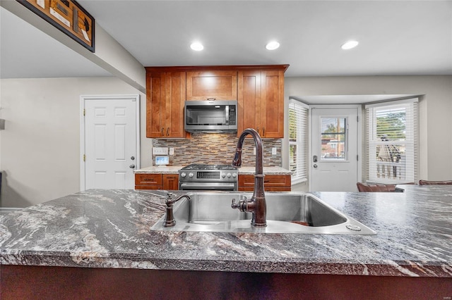 kitchen with tasteful backsplash, appliances with stainless steel finishes, and sink