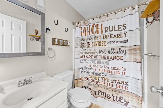 bathroom featuring curtained shower, toilet, and vanity