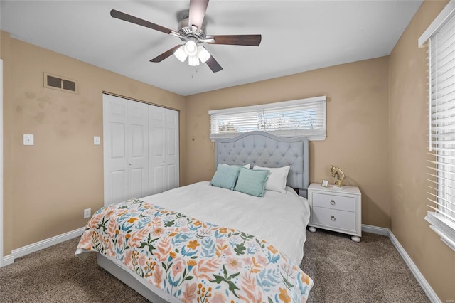 bedroom with ceiling fan, dark carpet, and a closet