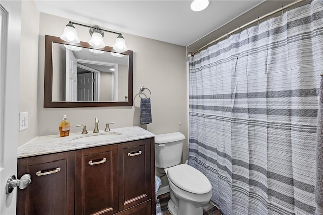 bathroom with toilet, vanity, and a shower with shower curtain