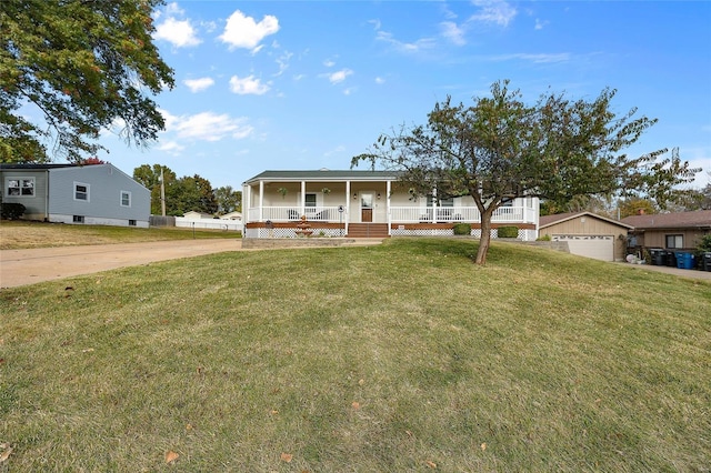 view of front facade with a front yard, covered porch, a garage, and an outdoor structure