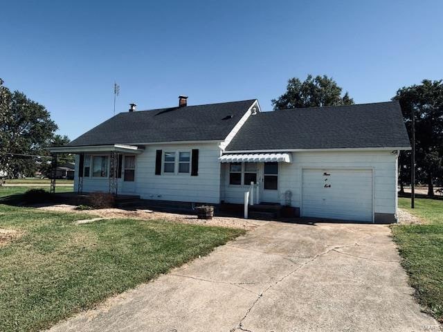 ranch-style house featuring a front lawn and a garage