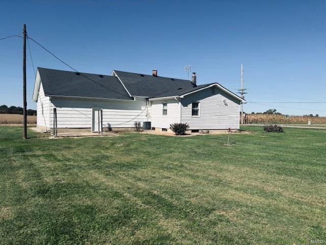 rear view of property with a yard