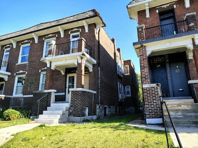 view of front of house featuring a front yard and a balcony