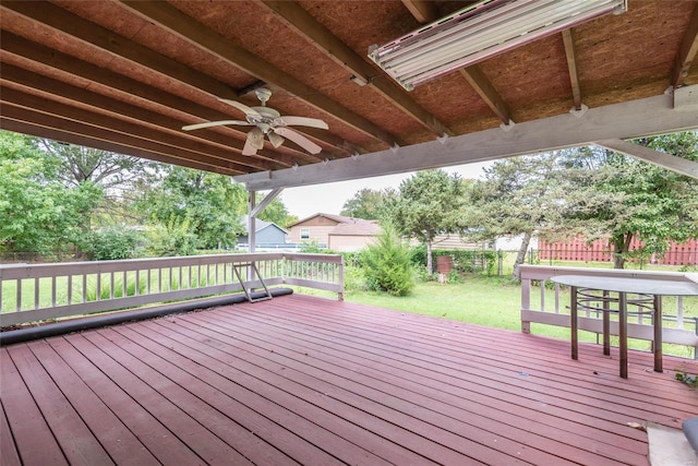 wooden deck featuring a lawn and ceiling fan