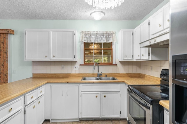 kitchen featuring stainless steel electric stove, tasteful backsplash, sink, and white cabinets