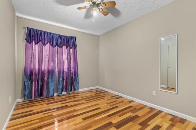 unfurnished room with a textured ceiling, wood-type flooring, and ceiling fan