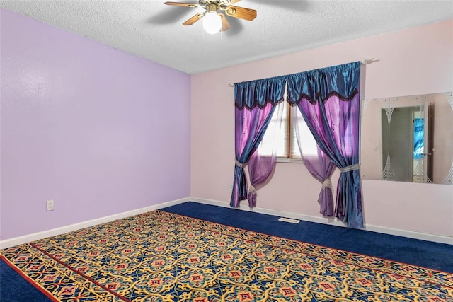 spare room with carpet floors, a textured ceiling, and ceiling fan