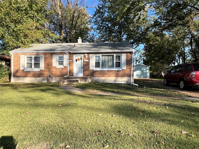 view of front facade featuring a front yard, an outbuilding, and a garage